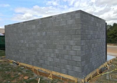 New concrete block structure under construction with wooden foundation